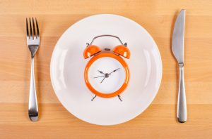 Orange Clock on Plate to Represent Time Added to Life with Calorie Restriction | Vitacost.com/blog
