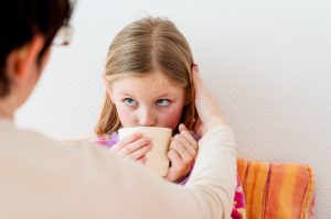 Parent Providing Natural Earache Relief to Sick Child Sipping Tea | Vitacost.com/blog