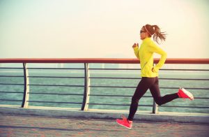 Sprinting Woman in Yellow Jacket Following HIIT Workout Program | Vitacost.com/blog