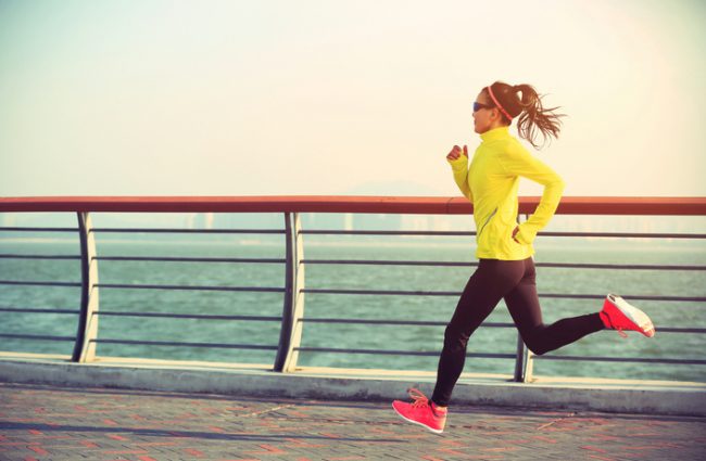Sprinting Woman in Yellow Jacket Following HIIT Workout Program | Vitacost.com/blog