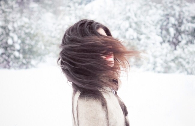 Woman with frizzy hair twirling in snow #frizzyhairtips | Vitacost.com/blog