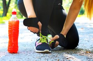 Runner Unaware of the Dangers of Energy Drinks Stopping to Tie Shoe | Vitacost.com/blog