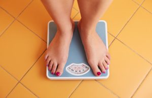 Woman Following the Ketogenic Diet Checking Her Weight on a Scale | Vitacost.com/blog