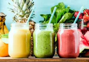 Yellow, green and pink smoothies in a row on wood | Vitacost.com/blog