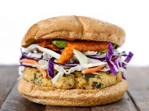 Falafel burger on a gluten-free bun with rainbow slaw and spicy tahini sauce | Vitacost.com/blog