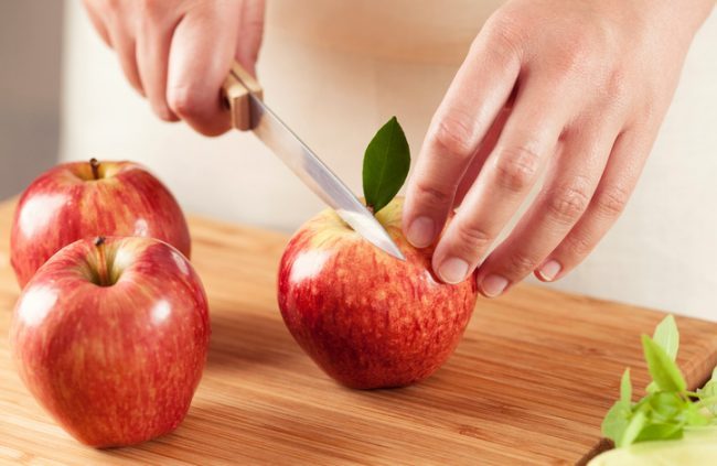 Cutting Non-Browning, GMO Apples on Cutting Board | Vitacost.com/blog