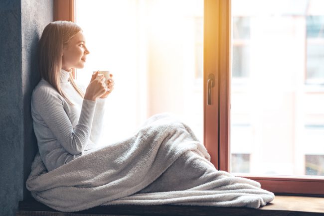 How to Get Over a Break Up - 20 Healthy Ways to Leave Your Lover Woman Going Through Break Up Sitting Beside Window Drinking Tea | Vitacost.com/blog