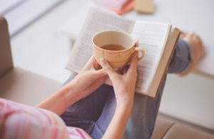 Woman Reading Book & Drinking Tea to Practice Self Love for Valentine's Day | Vitacost.com/blog
