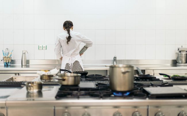 Sous Vide: Why Try This Trendy Cooking Technique? Woman in White Apron Cooking Sous Vide in a Modern Kitchen | Vitacost.com/blog