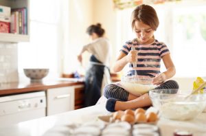 Girl Counter with Mixing Bowl in Lap Baking Healthy Food for Kids With Her Mother | Vitacost.com/blog