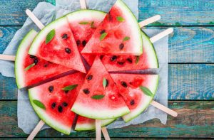 Superfood Sliced Watermelon Wedges Arranged in Circle on Blue Wooden Table | Vitacost.com/blog