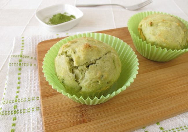 Two Green Tea Muffins on Wooden Cutting Board with Matcha Power in Background | Vitacost.com/blog