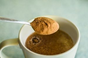 Collagen Powder on Spoon About to be Stirred into Cup of Coffee | Vitacost.com/blog