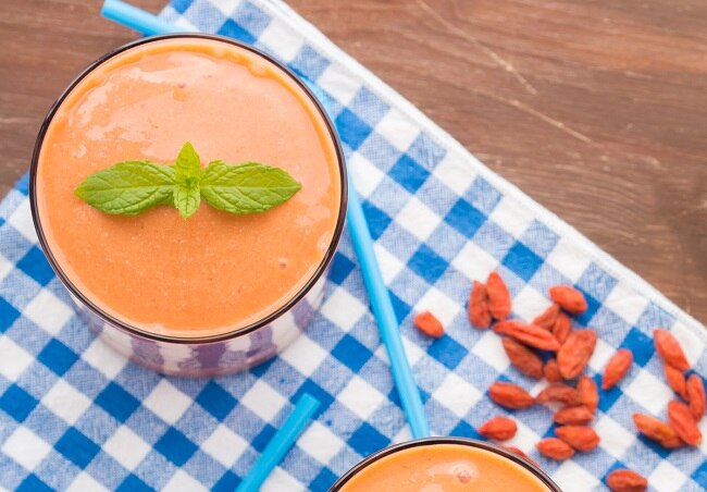 Homemade Coconut-Walnut Energy Milk Energizing Coconut, Walnut & Goji Berry Milk in Glass on Blue Checkered Napkin
