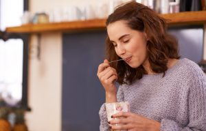 Satisfied-Looking Woman Following How to Lose Weight Tips Eating Delicious Yogurt | Vitacost.com/blog