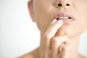 Woman Puts Fingers on Lips, Wondering if Titanium Dioxide is in Lipstick Ingredients | Vitacost.com/blog