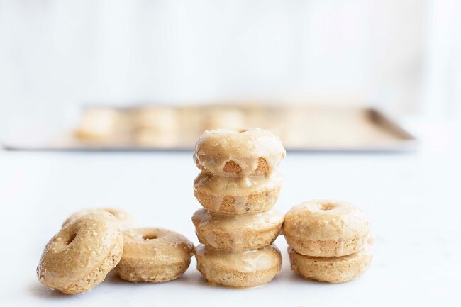 Stack of Mini Homemade Peanut Butter Donuts with Glaze on White Table #recipe | Vitacost.com/blog