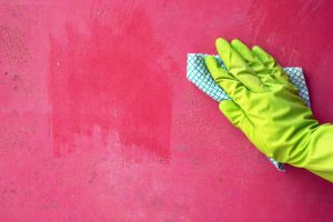 Person's Hand Wearing Glove Cleaning Wall with Mold | Vitacost.com/Blog