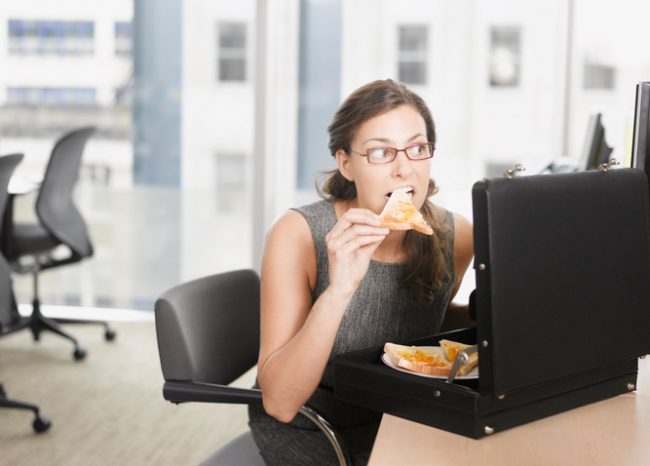 Woman Stress Eating Pizza From Briefcase at Office Desk | Vitacost.com/blog