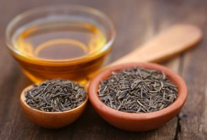 Black Cumin Seeds in Spoons Beside Bowl of Oil on Wooden Table | Vitacost.com/blog