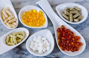 Assortment of Colorful Vitamins and Supplements in White Bowls on Marble Surface | Vitacost.com/blog