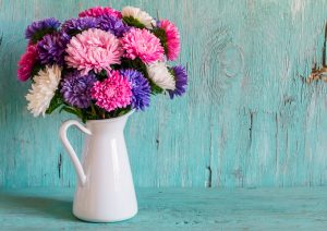 Pink and Purple Fresh-Cut Flowers in White Pitcher Vase on Teal Wooden Table | Vitacost.com Blog