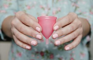 Woman With Pink Fingernails Holding Reusable Feminine Hygiene Menstrual Cup | Vitacost.com/blog