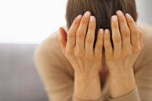 Woman Worried About Stress and Health Cradling Head in Hands | Vitacost.com/blog