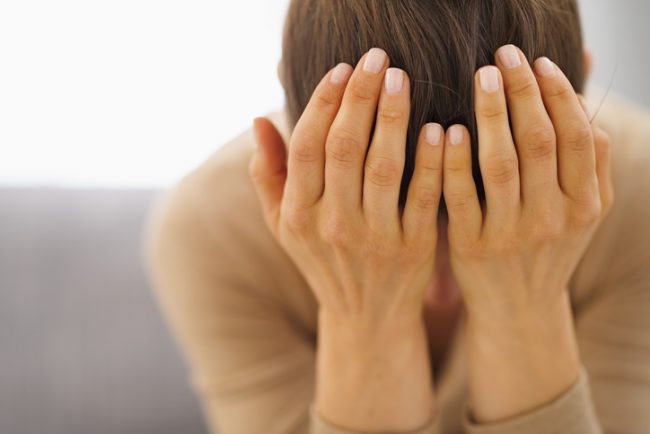Woman Worried About Stress and Health Cradling Head in Hands | Vitacost.com/blog