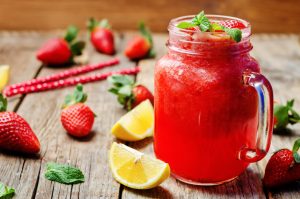 A Strawberry Lemonade Smoothie Infused with Vitamin C on Wood with Strawberries & Lemon | Vitacost.com/blog