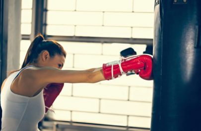 Woman Kickboxing with Punching Bag to Reduce Stress | Vitacost.com/blog