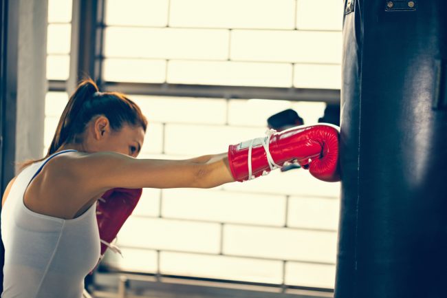 Woman Kickboxing with Punching Bag to Reduce Stress | Vitacost.com/blog