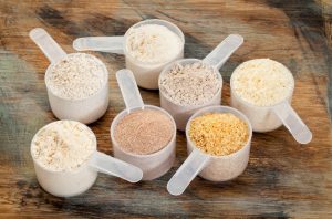 Assorted Gluten-Free Flours in Plastic Scoops on Wooden Table | Vitacost.com/blog