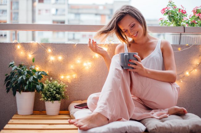 Woman Drinking Tea on Balcony in City With Clean Air | Vitacost.com/blog