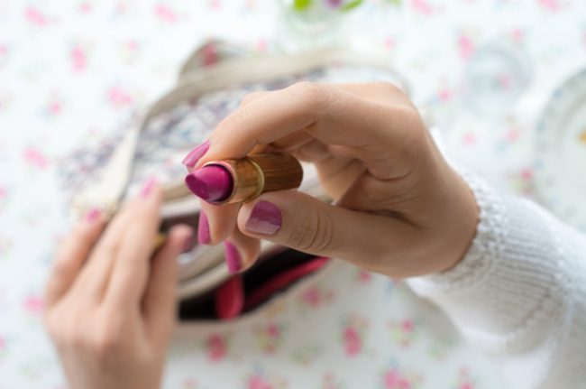 Woman Who Prefers Organic Beauty Products Opening Pink Lipstick | Vitacost.com/blog