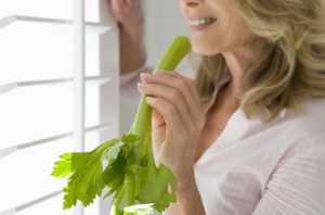 Woman Eating Stalk of Celery to Keep Aging Digestion Problems at Bay | Vitacost.com/blog