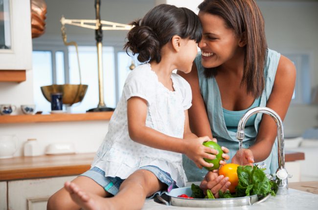 Woman Cooking at Home Washing Vegetables with Daughter | Vitacost.com/blog