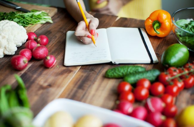 Woman Writing in Food Journal as Part of Elimination Diet Plan to Detect Gluten Sensitivity | Vitacost.com/blog