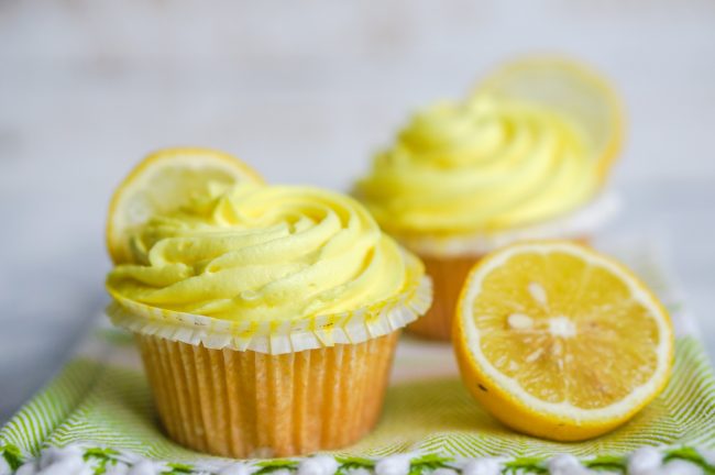 Lemon Cupcakes with Greek Yogurt Frosting  2 Lemon Cupcakes with Greek Yogurt Frosting & Lemon Wedge on Green Towel | Vitacost.com/blog