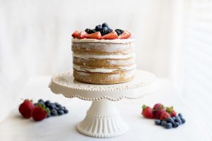 Side View of Rustic Naked Wedding Cake with Berries on White Cake Stand | Vitacost.com/blog