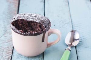 Brownie in a Pink Mug with Powdered Sugar on White Wood with Green Spoon #recipe | Vitacost.com/blog