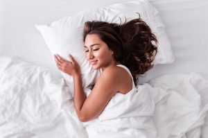 Woman Taking Melatonin for Sleep Support Happily Sleeping in Bed | Vitacost.com/blog