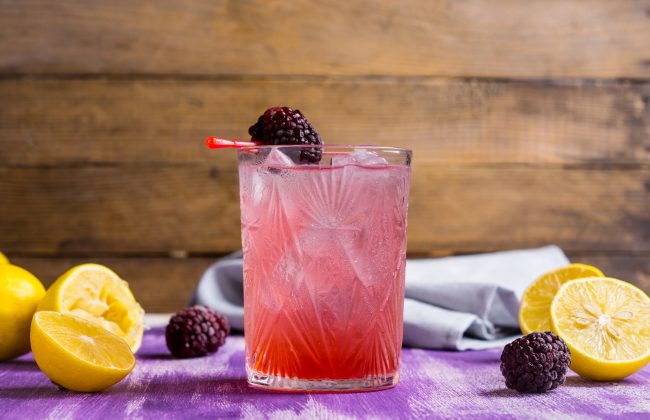 Healthy Blackberry Cocktail Drink with Lemons on Purple Table with Wood Backdrop | Vitacost.com/blog