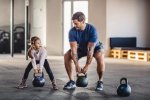 Father Lifting Kettlebells with Young Daughter | Vitacost.com/Blog