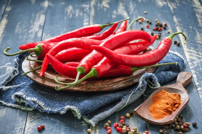 Spicy Foods Including Red Chili Peppers Arranged on Blue Wooden Table | Vitacost.com/blog