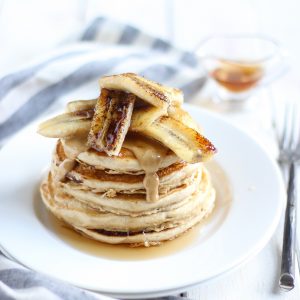 Vegan Vanilla Protein Pancakes Topped with Caramelized Bananas & Syrup on White Plate | Vitacost.com/blog