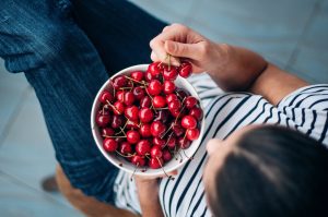 Woman Not Suffering From Fructose Intolerance Enjoying Bowl of Cherries | Vitacost.com/blog