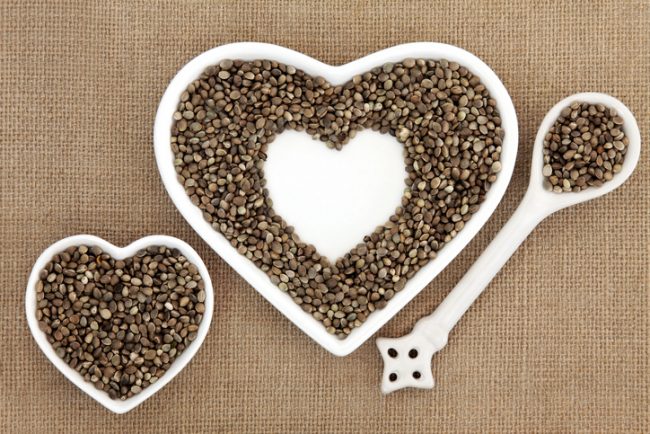 Bottle of Hemp Oil & Scoop Filled With Hemp Seeds on Wooden Table | Vitacost.com/blog