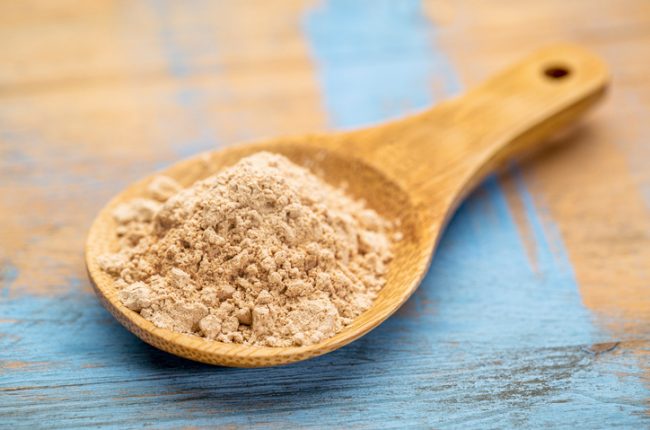 Scoop of Maca Root Powder in Large Spoon on Wooden Table | Vitacost.com/blog