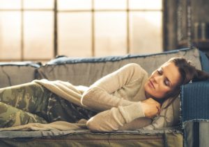 Woman Enjoying the Benefits of Napping Curled up on Couch Asleep | Vitacost.com/blog